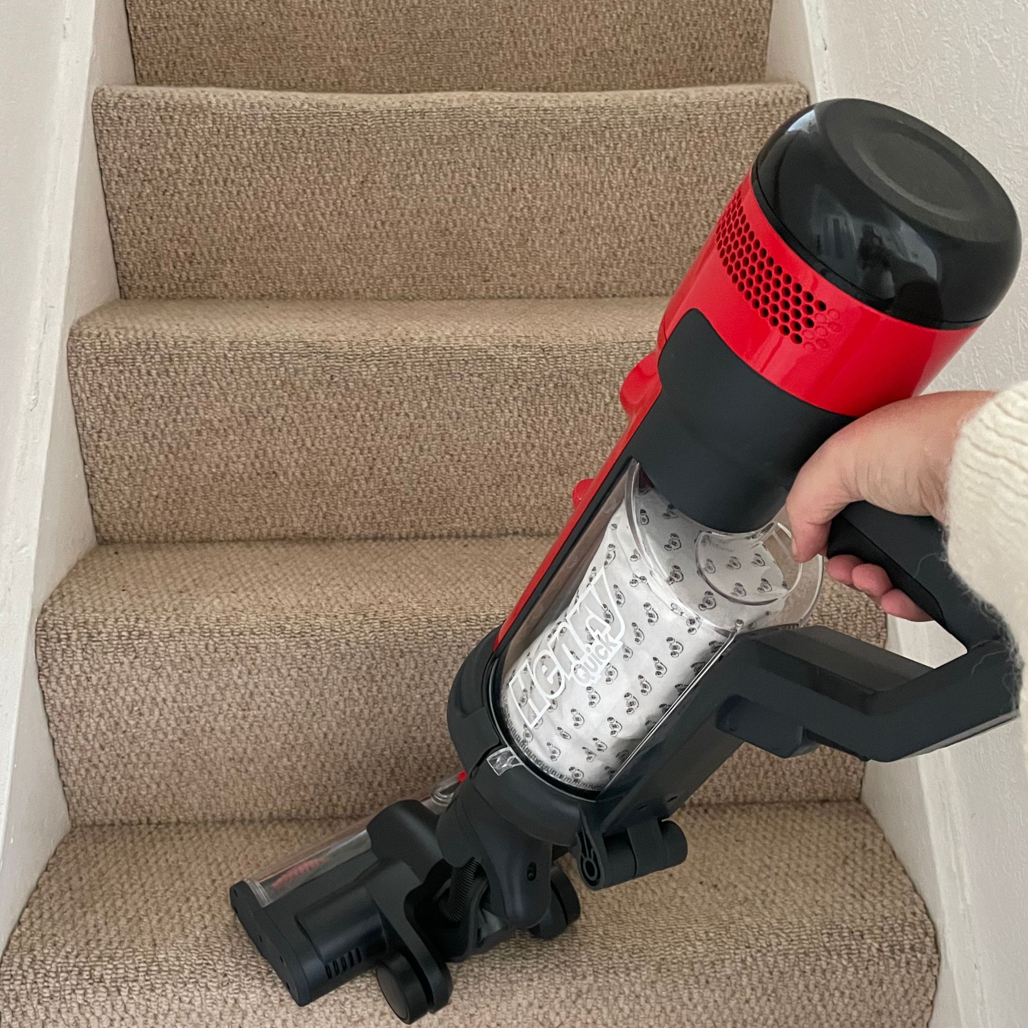 Using the Henry Quick Corded Vacuum Cleaner in handheld mode to clean beige carpeted stairs
