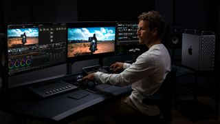 A person using the Apple Mac Pro computer with two monitors.