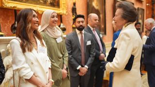 Princess Anne, Princess Royal talks with Mylene Klass (L) and Abtaha Maqsood (C) during a reception celebrating exceptional individuals and organisations contributing towards humanitarian efforts