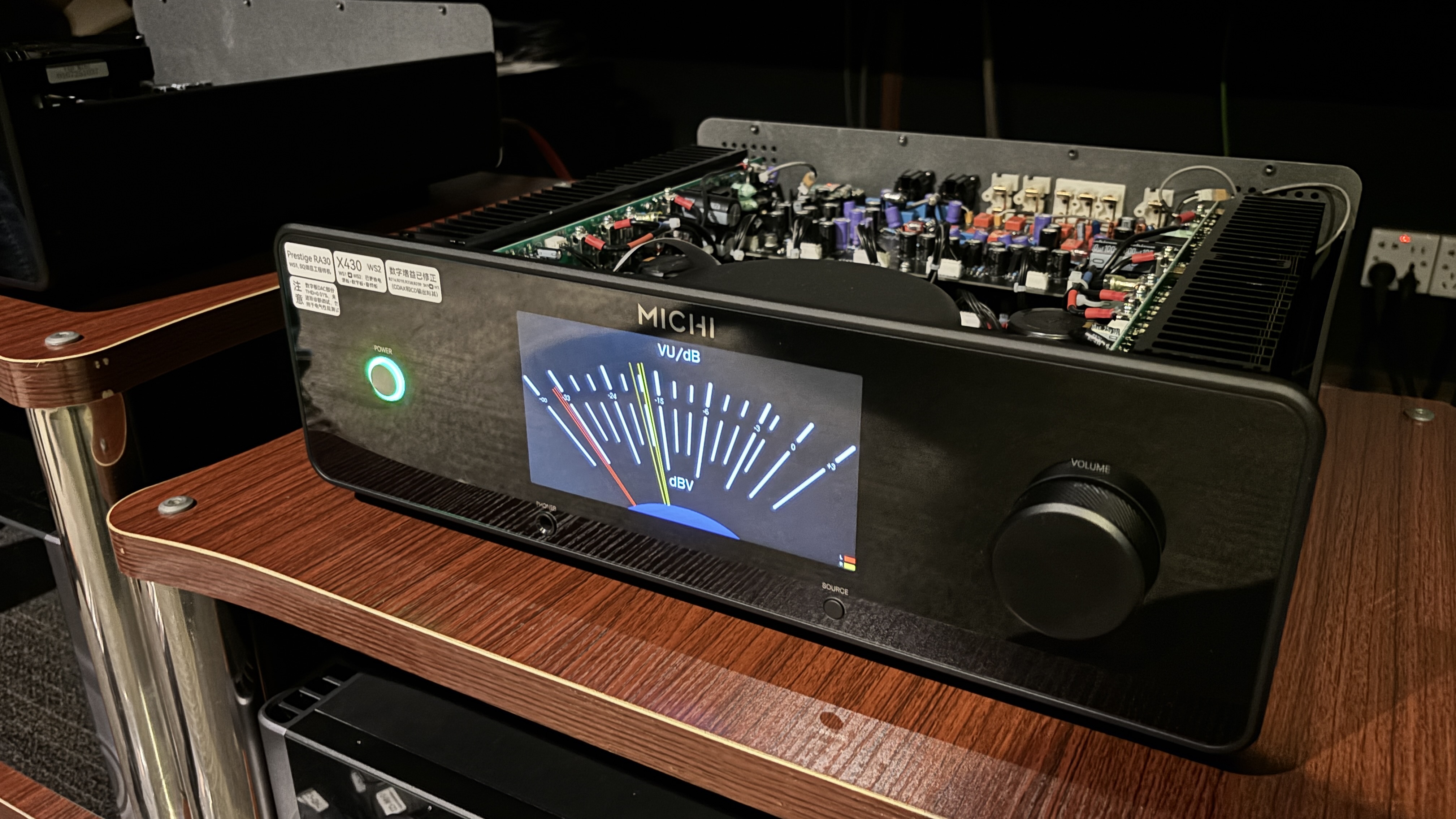 Michi Prestige X430 integrated amplifier on a hi-fi stand showing a VU meter on its display