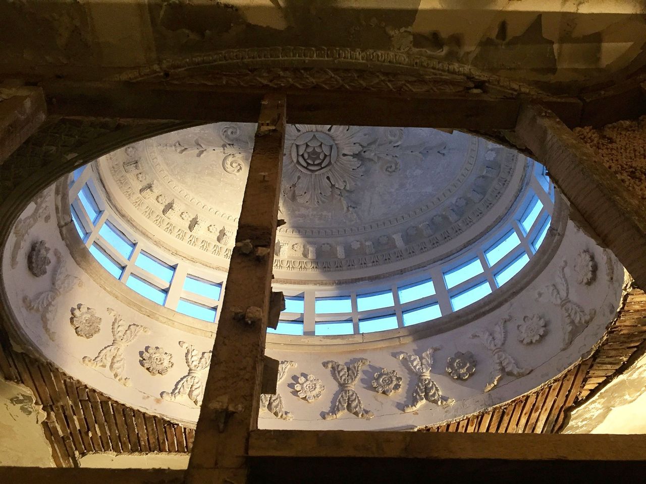 A dilapidated roof light in need of repair with a wooden pole holding it up