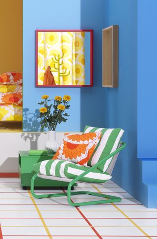 Green metal tube chair with an orange sunflower pillow in a blue room