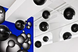 Black balls floating in air with blue & black artwork