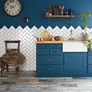 kitchen with white mosaic tiles o wall with blue wall and wooden flooring wooden chair and wooden countertop with wash basin