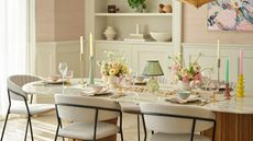a spring table with floral centerpieces colorful candlesticks and a table lamp