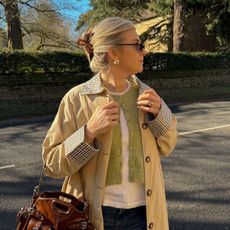 Woman wears checked collar trench coat, green cardigan, white t-shirt