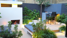 beautiful modern courtyard garden in the evening with discreet LED lighting and a fireplace