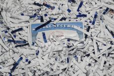 Social Security Card partially hidden amongst shredded documents. Document shredding, identity theft and fraud concept