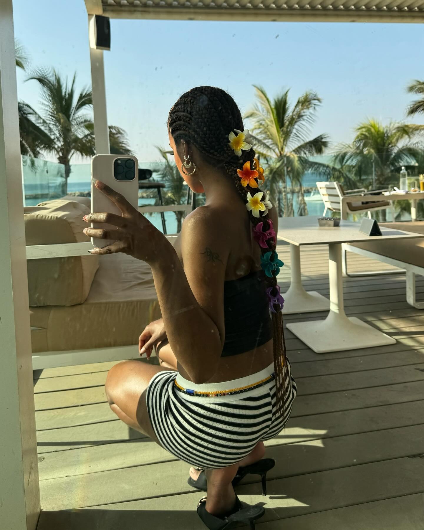 @mv.tiangue taking a selfie in a mirror wearing multiple flower claw clips in her hair