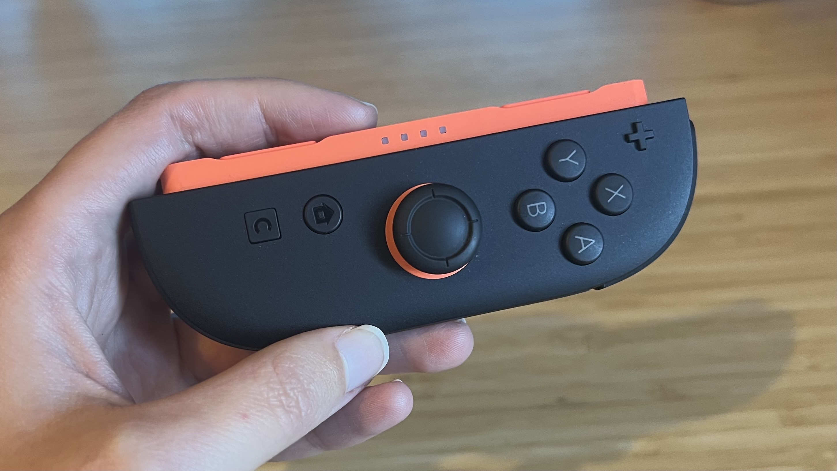 Hand holding Nintendo Switch 2 Joy-Con controller