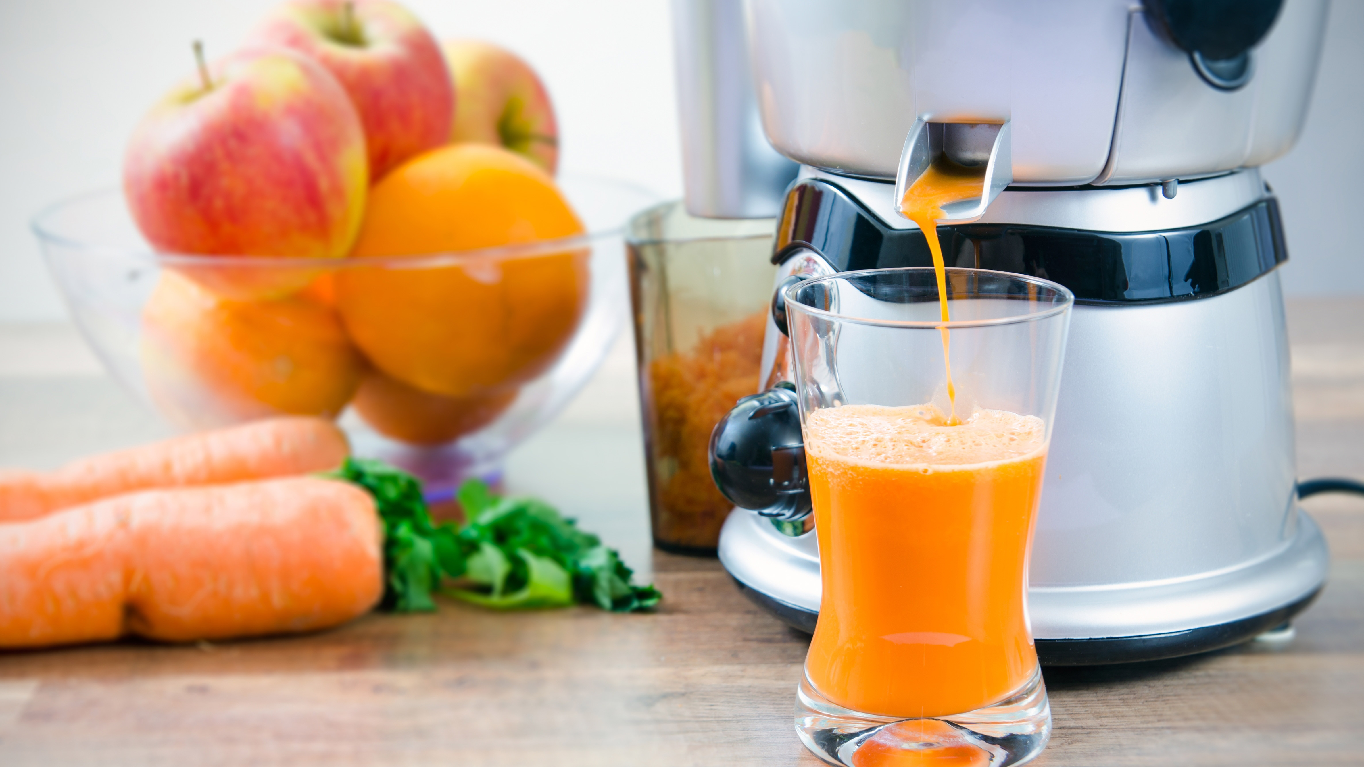 Juicer digunakan untuk membuat jus jeruk dan dikelilingi oleh buah