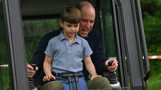 Prince William, Prince of Wales is helped by Prince Louis of Wales (L) as he uses an excavator while taking part in the Big Help Out, during a visit to the 3rd Upton Scouts Hut on May 8, 2023 in London, England