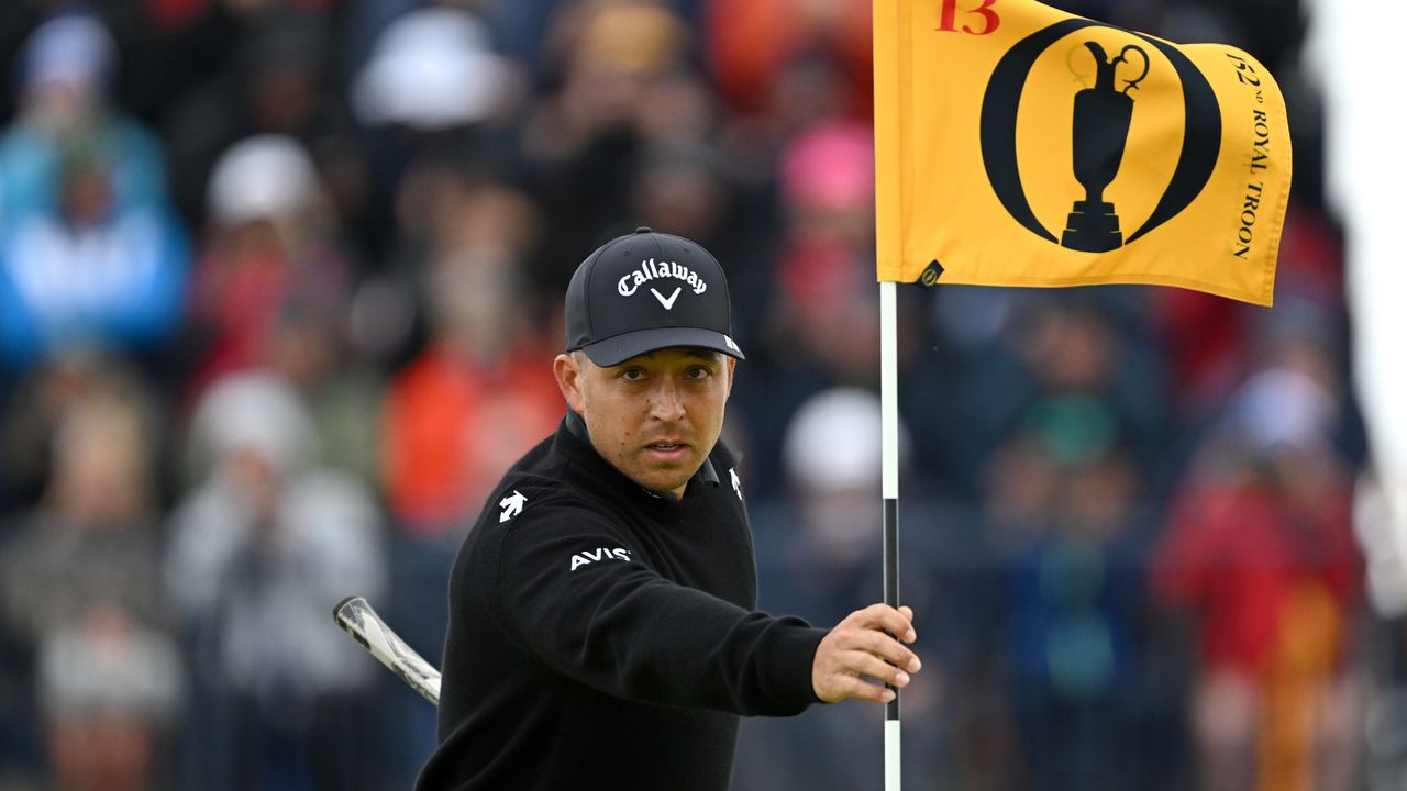  Xander Schauffele of the United States replaces the pin flag on the 13th hole on day one of The 152nd Open championship at Royal Troon on July 18, 2024 in Troon, Scotland.