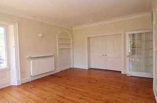 Before picture of dining room with magnolia walls and wooden floorboards