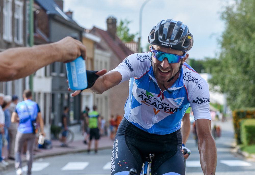 Clement Carisey reaches for an Israel Cycling Academy bottle