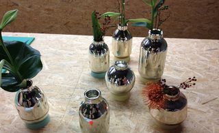 Reflective glass vases filled with flowers.