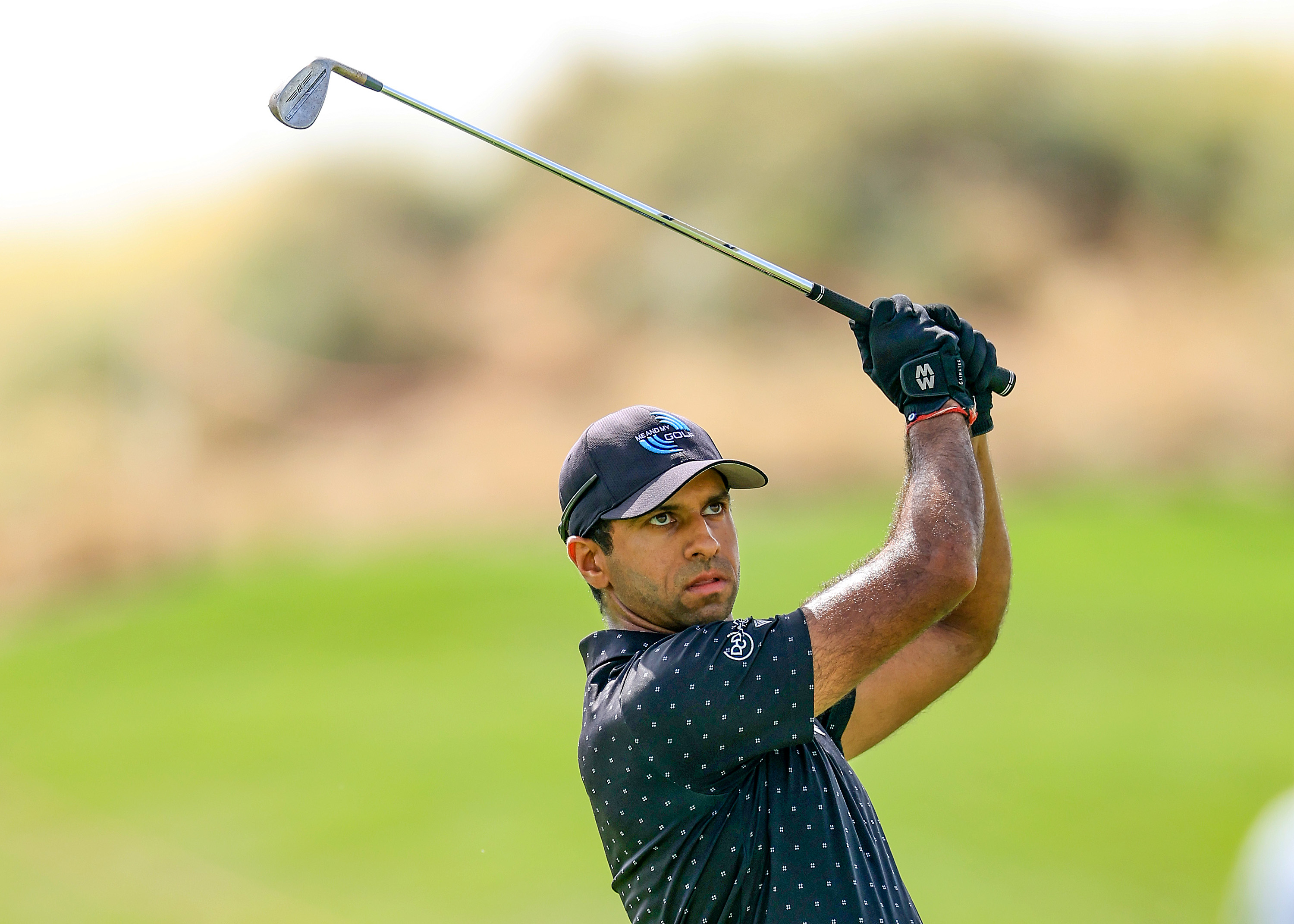 Aaron Rai hits a wedge shot and watches its flight