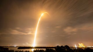 a time lapse photo captures the bright streak of a rocket lifting off into the night sky from Florida