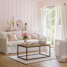 Pink living room with wall panelling and patio doors open to garden