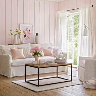 Pink living room with wall panelling and patio doors open to garden