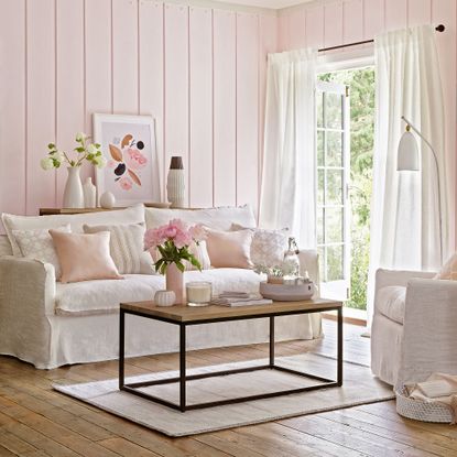 Pink living room with wall panelling and patio doors open to garden