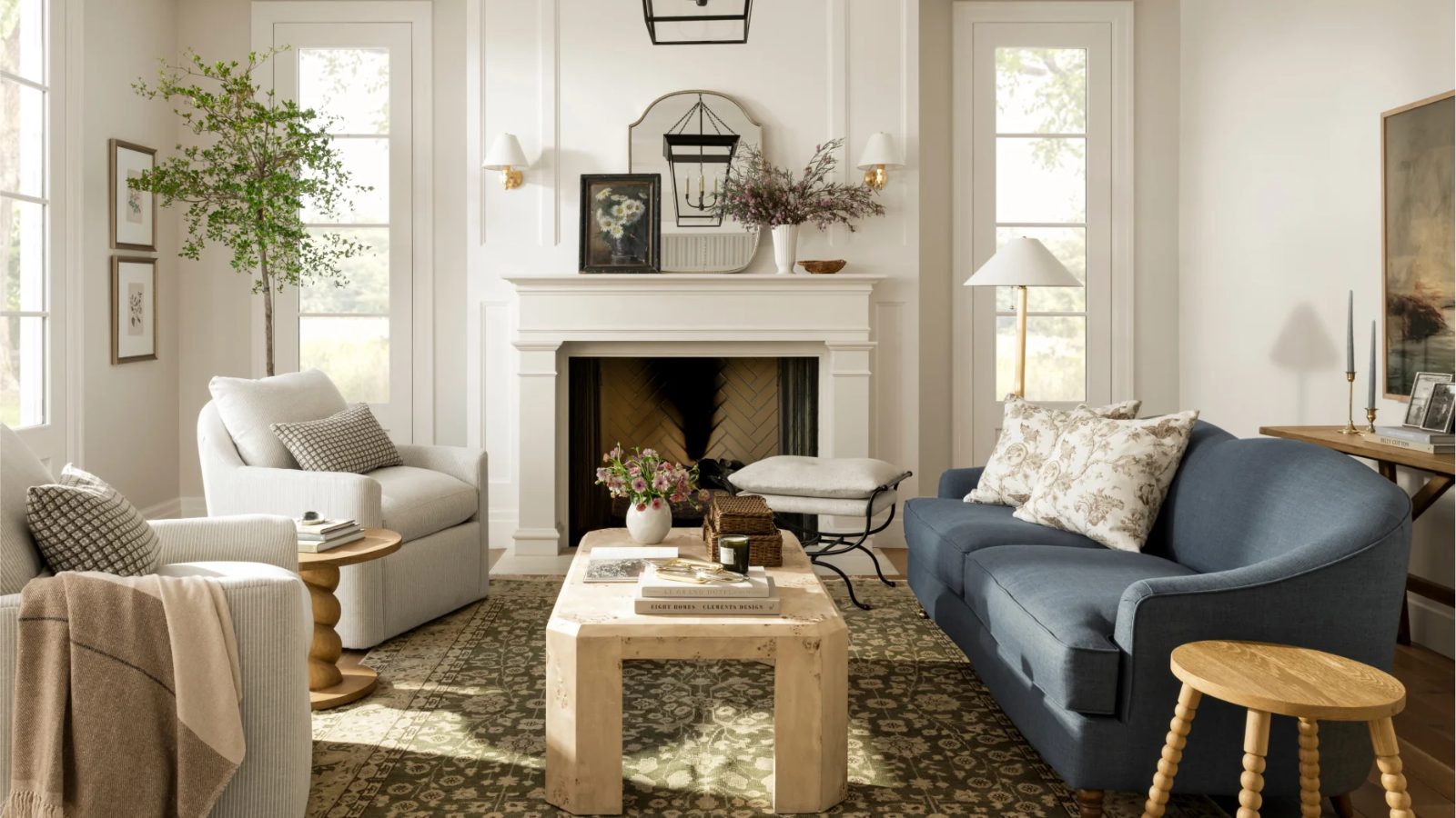 a neutral living room with light wood accent decor, a blue couch, and a large fireplace 
