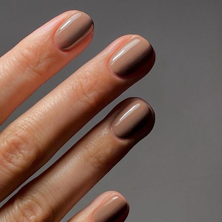 A close-up of a light brown, cappuccino-inspired manicure
