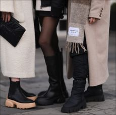 Annabel Rosendahl (L) is seen wearing Copenhagen Studios CPH 276 Vitello black/ pale beige boots, Copenhagen Studios black clutch bag and Dorothee Schumacher creme white wool coat; Marie Hindkaer (M) is seen wearing a black Prada nylon bag, black leather Copenhagen Studios CPH145 boots, creme white Samsoe Samsoe knit sweater, Acne Studios black short skirt and a black Jw Anderson x Uniqlo jacket; Mie Juel (R) wears Copenhagen Studios beige wool scarf, Copenhagen Studios CPH149 black boots, Birgitte Herskind beige wool coat and black Basic Apparel pants, on November 15, 2022 in Reykjavik, Iceland. (Photo by Jeremy Moeller/Getty Images for Copenhagen Studios)