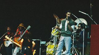 Frank Zappa performs on stage with band members (L-R) Denny Walley, Ike Willis, Arthur Barrow (back to camera) and drummer Vinnie Colaiuta at The Knebworth Festival on September 9th, 1978 