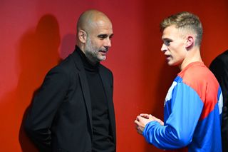 Pep Guardiola, Manager of Manchester City, speaks with Joshua Kimmich of FC Bayern Munich in the tunnel after the UEFA Champions League quarterfinal second leg match between FC Bayern München and Manchester City at Allianz Arena on April 19, 2023 in Munich, Germany