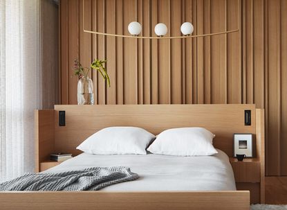 A bedroom with white sheets and wooden panelling