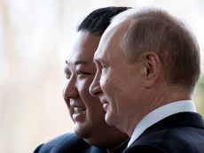 Kim Jong Un stands next to Vladimir Putin.