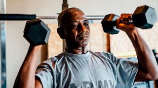 Man holding dumbbells by his shoulders