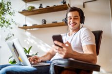 Man listening music while working on laptop