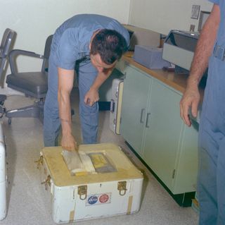 NASA photographer Terry Slezak unpacks the first Apollo 11 film container.