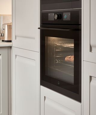 A self-cleaning built-in oven in a traditional white kitchen