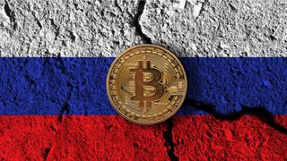 Bitcoin on a Russian flag with a crack through it.