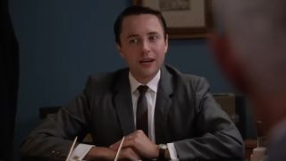 Vincent Kartheiser in a suit and tie sitting at a desk on Mad Men