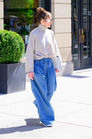 Jennifer Lopez walks out of her Manhattan apartment wearing wide leg jeans and a slouchy sweater
