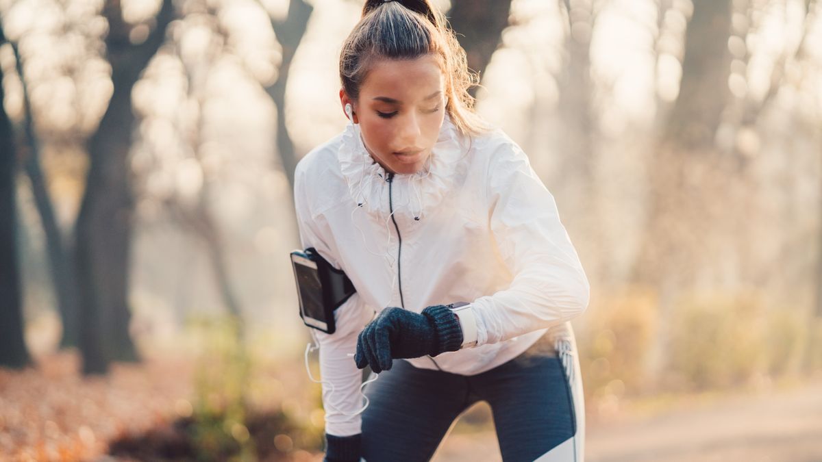 Woman checking watch while running