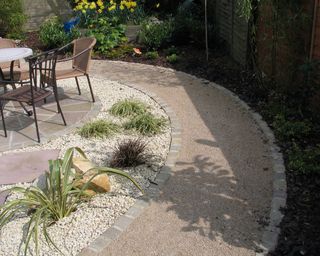curved gravel path around the edge of a patio
