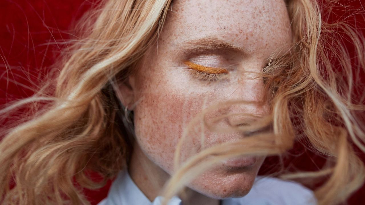 Woman with freckles wearing coloured eye liner