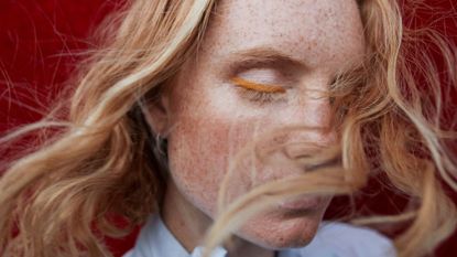 Woman with freckles wearing coloured eye liner