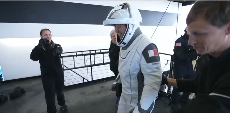 astronauts hold wave aboard a spaceship