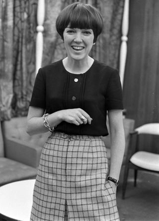 British fashion designer Mary Quant wearing a plaid skirt