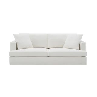 A rectangular white cloud couch with two square throw pillows on it