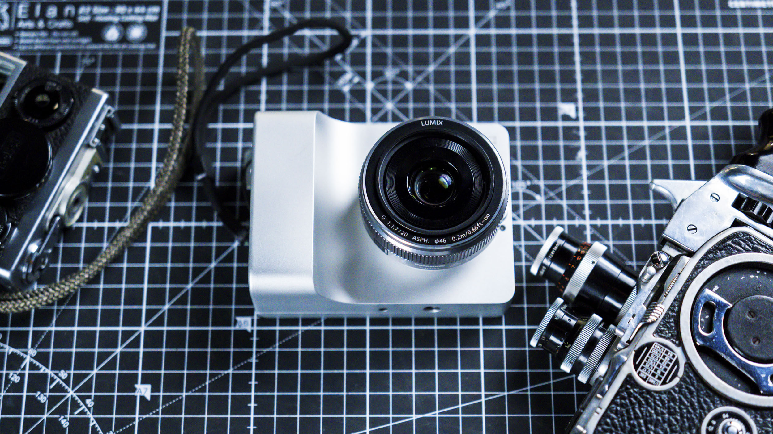 Caira camera on a grid mat alongside classic cameras