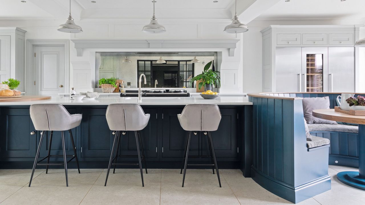 Blue kitchen renovation with grey bar chairs and quartz table tops