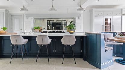 Kitchen island with sink in and grey bar chairs part of a kitchen renovation