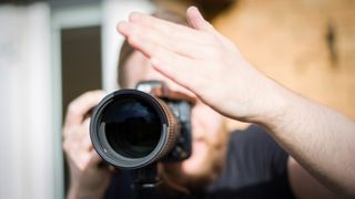 A photographer using his hand as a lens hood